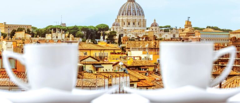 european city with cathedral dome in background, two white cups in foreground